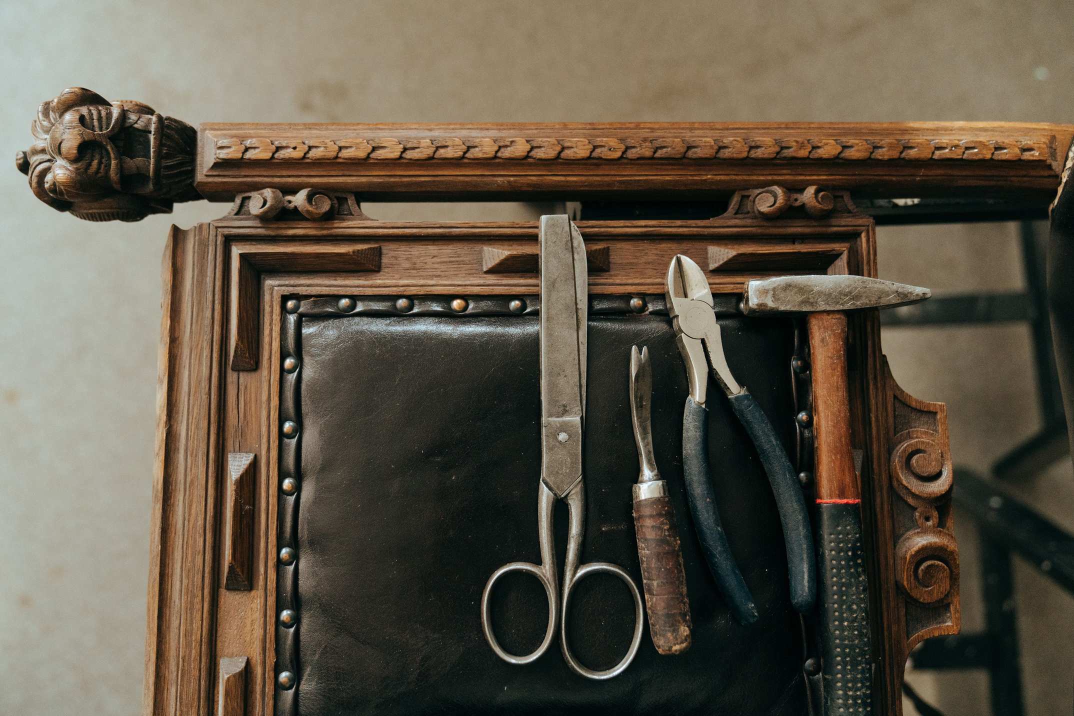 Vintage tools on an antique wooden chair in a workshop setting